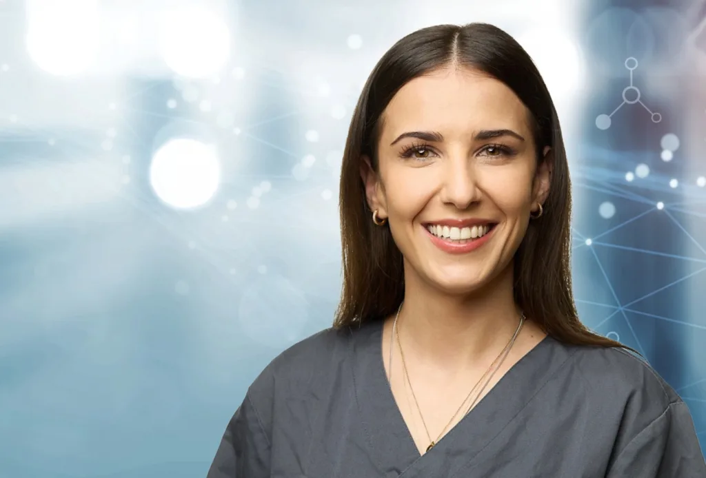 Junge Frau mit dunklen Haaren und dunkel grauem Oberteil. Blauer Hintergrund