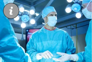 Drei Ärzte in blauen Operationskleidern in Operationssaal. Übergeben einenander Werkzeug und schauen sich an.